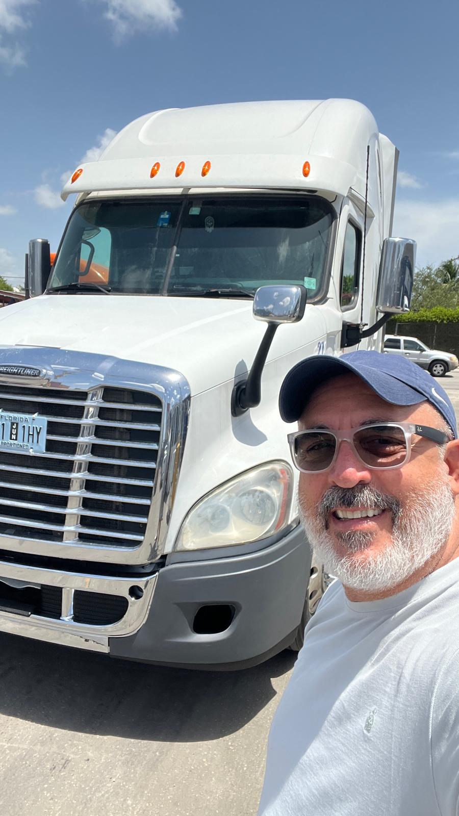 Representante de TEDESCARGO junto a un camión Freightliner preparado para envío