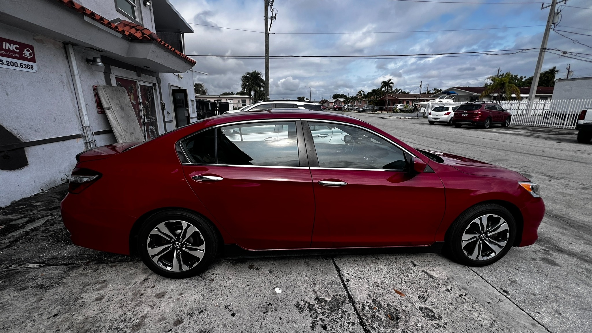 Vista lateral de un Honda Accord rojo preparado para recogida