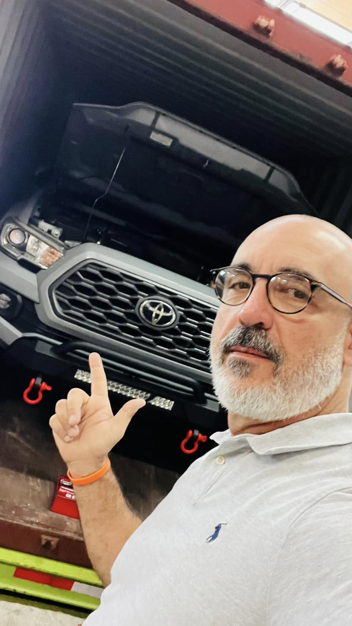Representante de TEDESCARGO junto a una Toyota Tacoma preparada para embarque